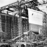 Titanic (vlevo) v loděnici v Belfastu